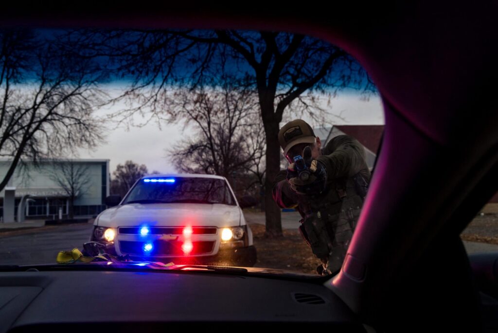 Law enforcement officers exiting a vehicle to perform an undercover rescue during training.