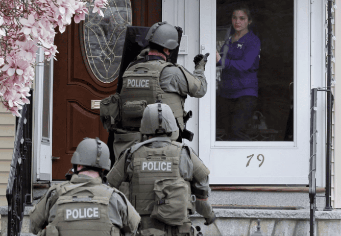 Police officers conducting a security operation at a residential property.