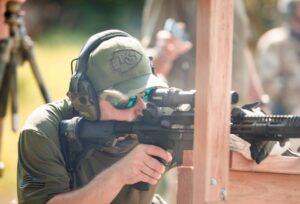 Law enforcement student practicing kneeling barricade position with LPVO-equipped patrol rifle during instructor training