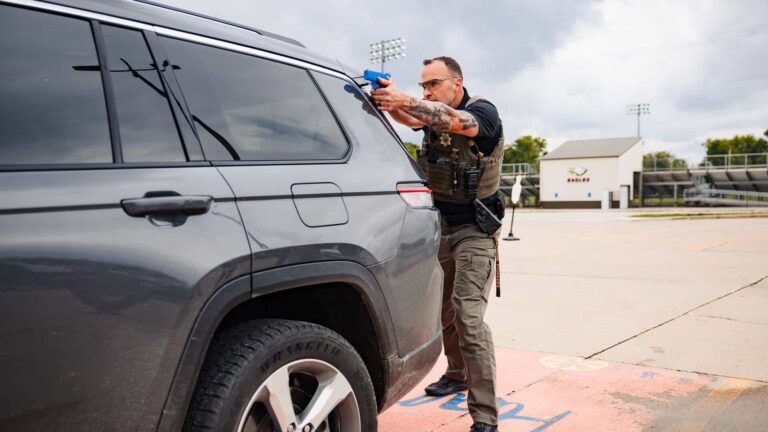 School Resource Officer practicing bounding movement and using a vehicle for cover during S.R.O. Tactical Assailant Response open-area tactics training