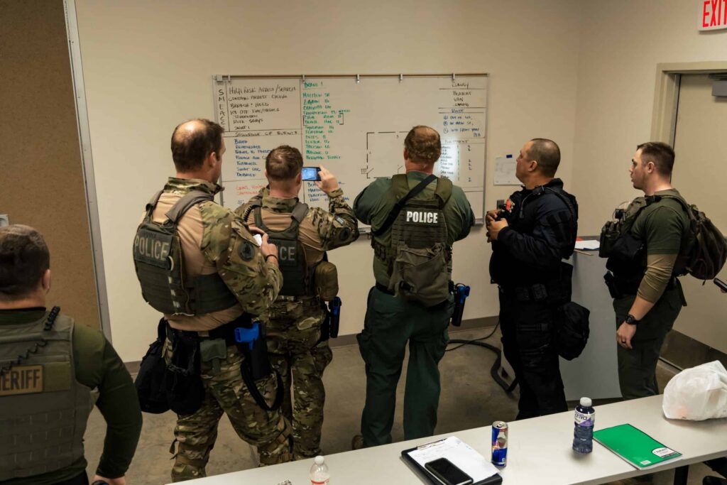 SWAT team leaders discussing SMEAC planning during a basic SWAT training course