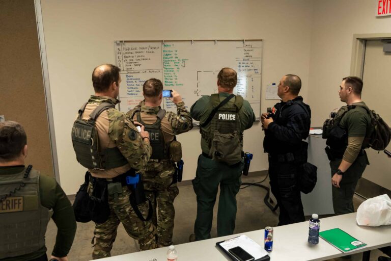SWAT team leaders discussing SMEAC planning during a basic SWAT training course